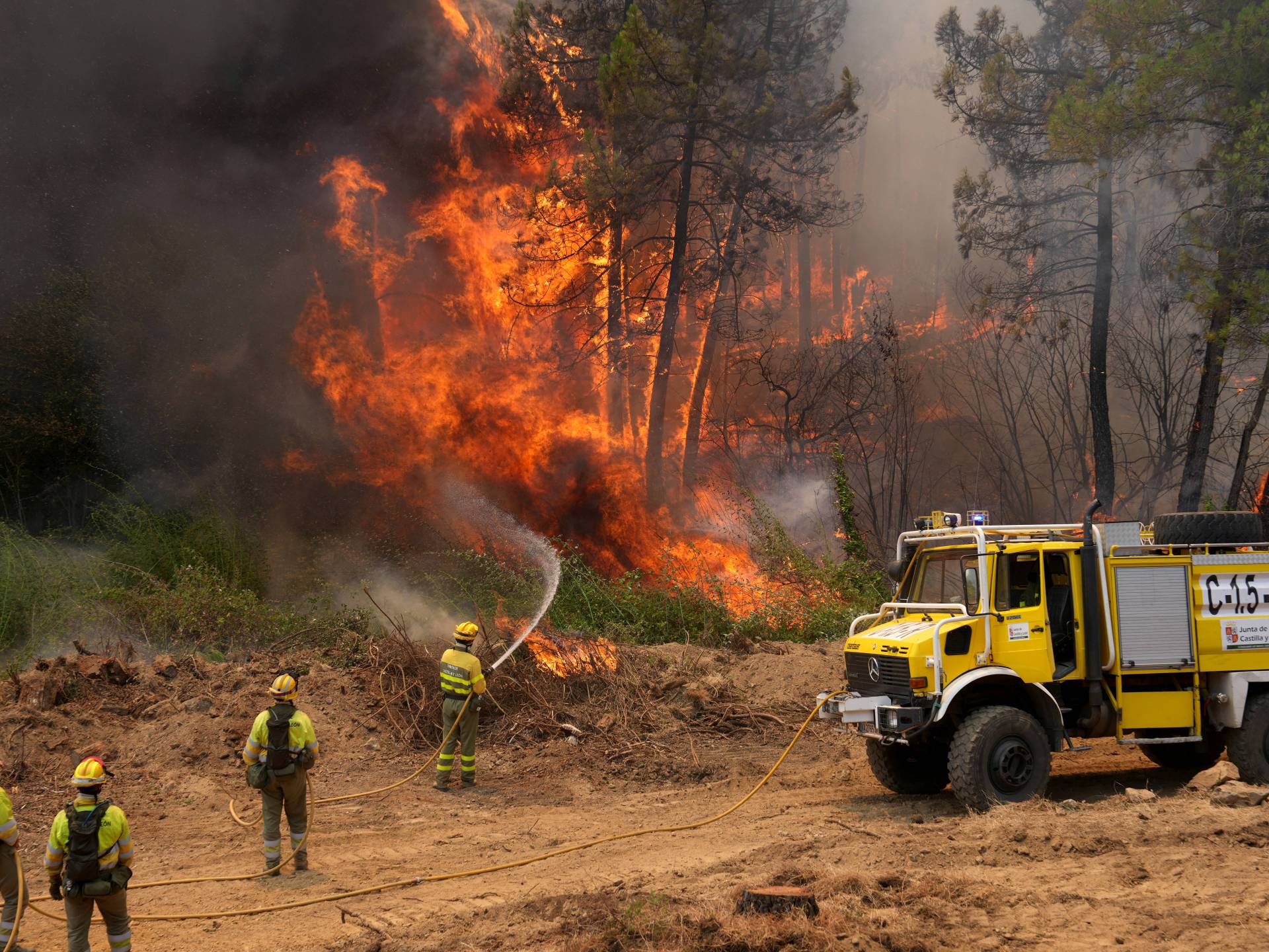 Castilla-y-Leon district's firefighters battle a fire surrounding La Atalaya residential area in El Tiemblo, 80 kms west of Madrid, on July 25, 2026 amid wildfires that have burned up to 25,000 hectares.