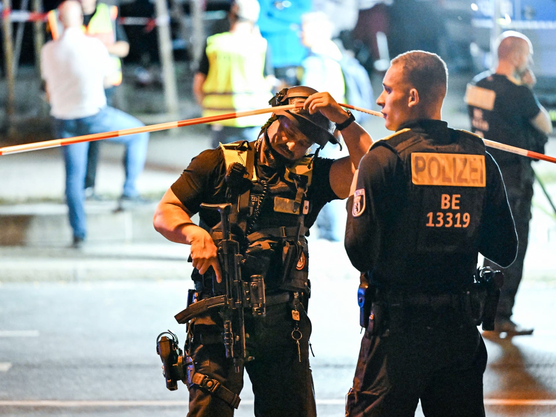 Armed police stand near the scene where one person was killed and around 16 injured after a car struck people on the outskirts of the Christopher Street Day (CSD) parade in Berlin, on July 25, 2026.