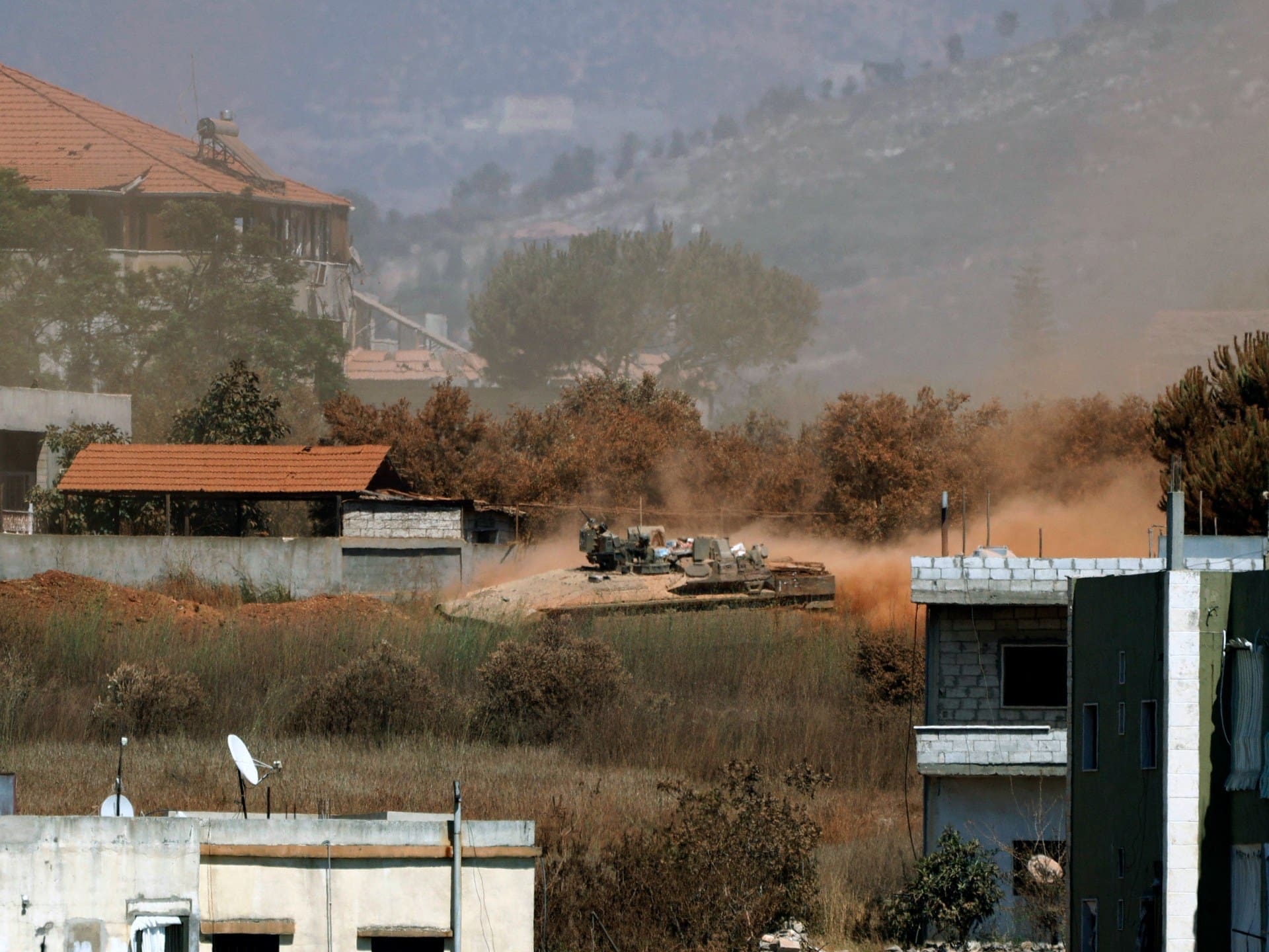 A photograph taken from the southern Lebanese village of Zawtar al-Gharbiyah shows Israeli armoured vehicles manoeuvering in the nearby village of Zawtar al-Charkiyah on July 28, 2026.
