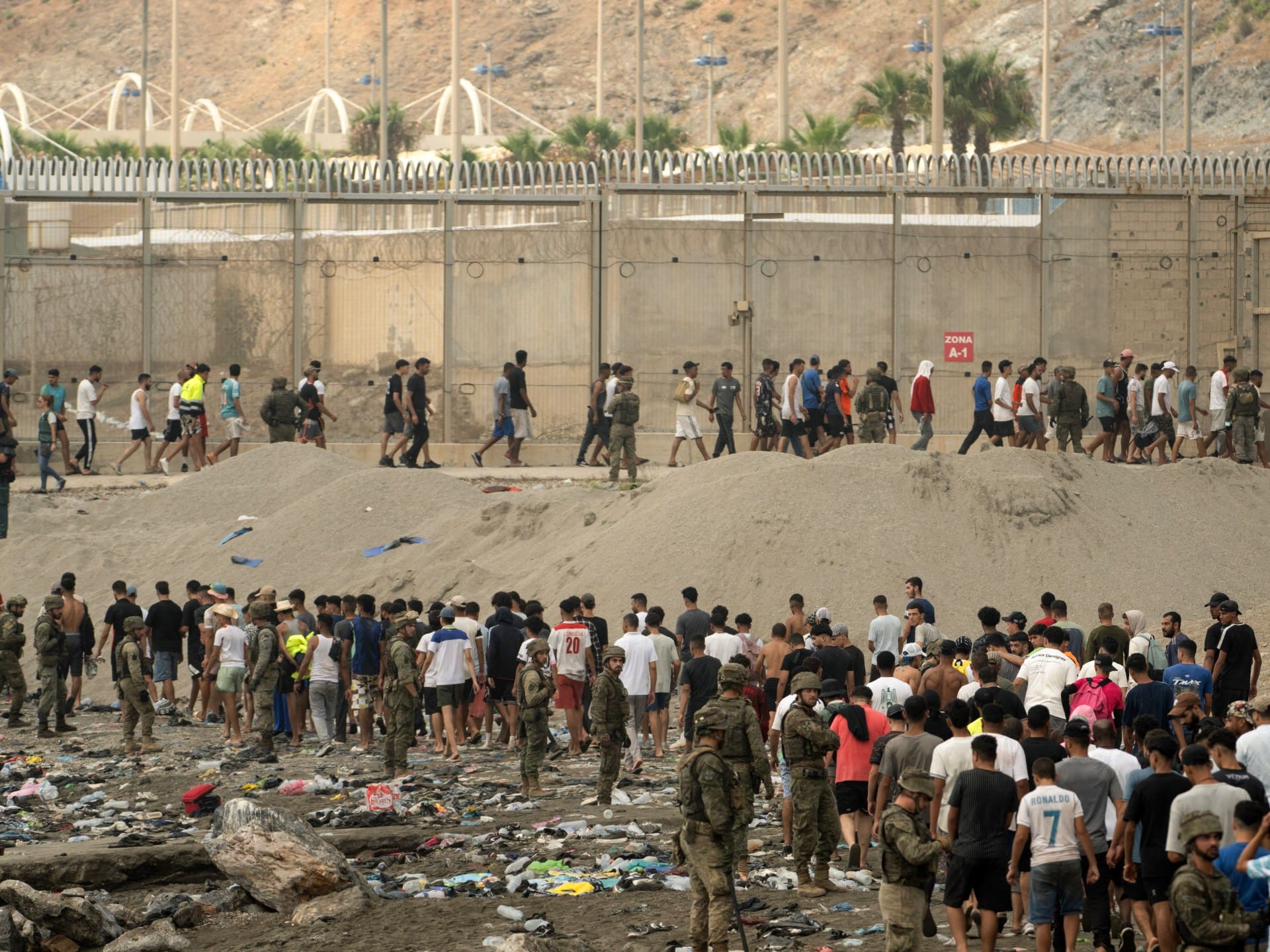 Spanish soldiers control as migrants cross back to Morocco after they crossed the border to enter Spain's north Africa's Ceuta enclave on July 31, 2026.