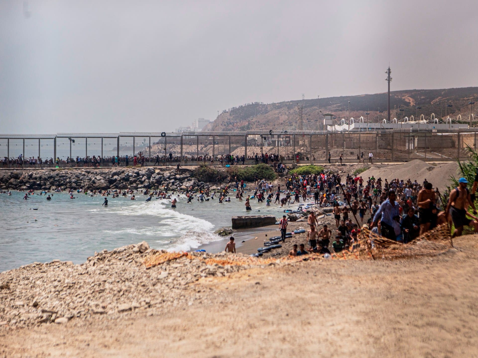 Migrants cross from Morocco into the Spanish enclave of Ceuta, Thursday, July 30, 2026. (AP Photo/Antonio Sempere)