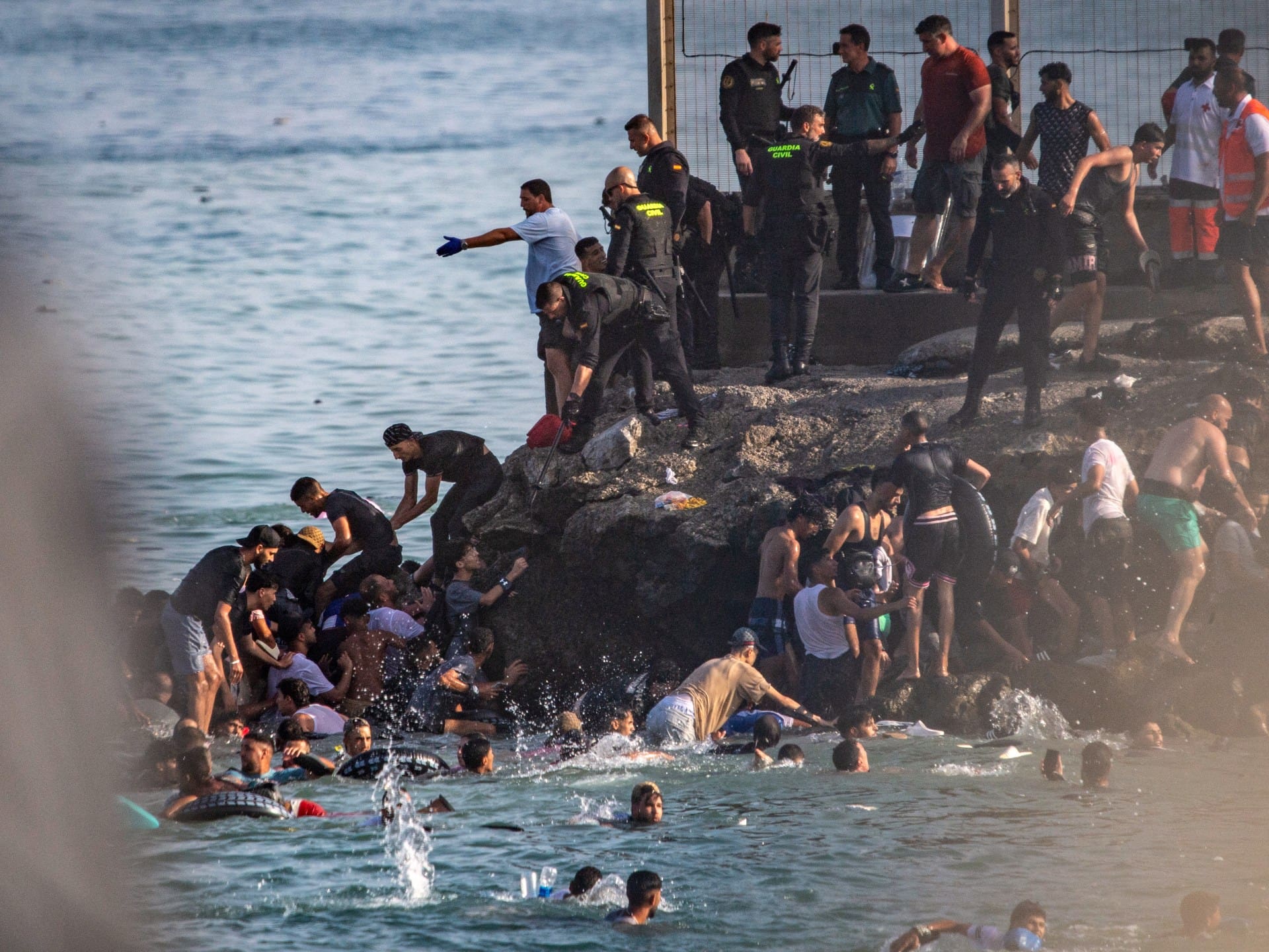 Migrants try to cross from Morocco into the Spanish enclave of Ceuta, Thursday, July 30, 2026. (AP Photo/Antonio Sempere)