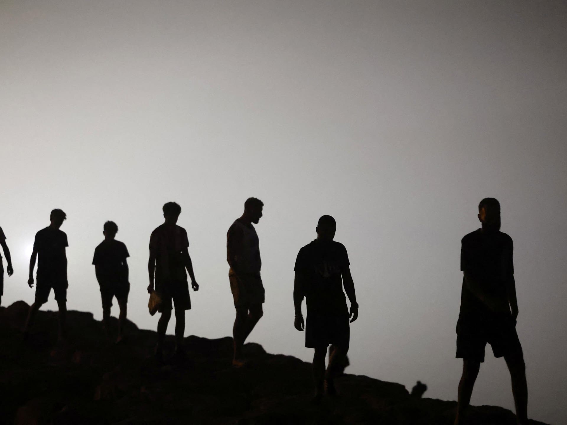 Migrants walk towards the Fnideq region in northern Morocco after leaving Spain's North African enclave of Ceuta near the town of Fnideq, on the Morocco-Spain border, following an attempted to cross at the Bab Sebta border crossing, on the Morocco-Spain border on August 1, 2026.